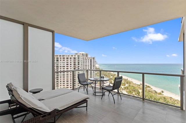 balcony featuring a view of the beach and a water view