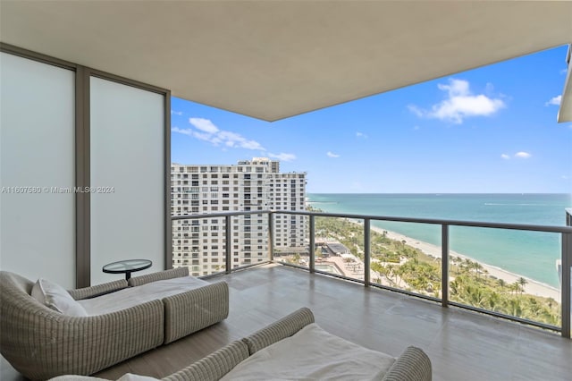 balcony with a water view and a view of the beach