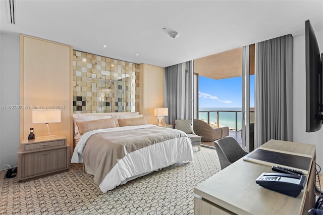 bedroom with a water view and access to exterior