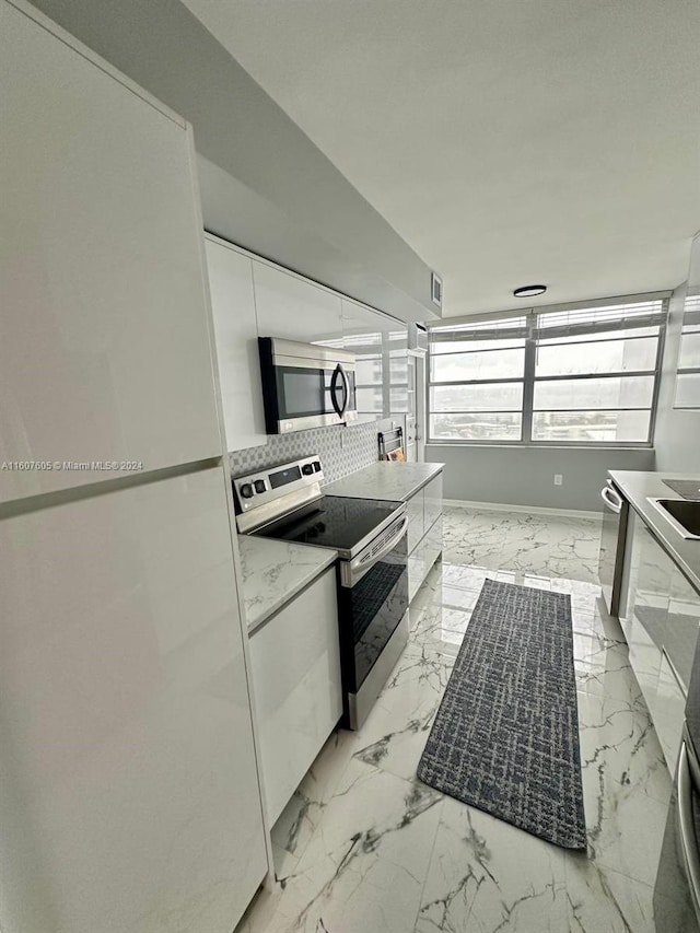 kitchen with white cabinetry, sink, tasteful backsplash, and appliances with stainless steel finishes