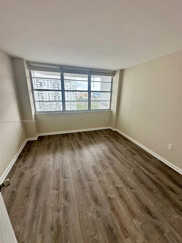 unfurnished room with dark hardwood / wood-style flooring