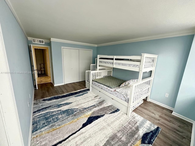 bedroom featuring ornamental molding, dark hardwood / wood-style flooring, and a closet