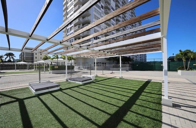 view of property's community with a pergola and a lawn