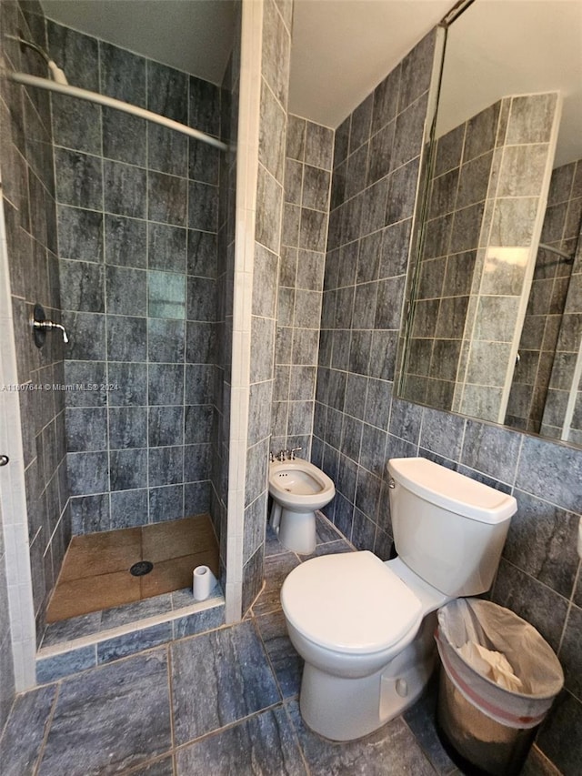 bathroom with tile patterned floors, tiled shower, tile walls, and toilet