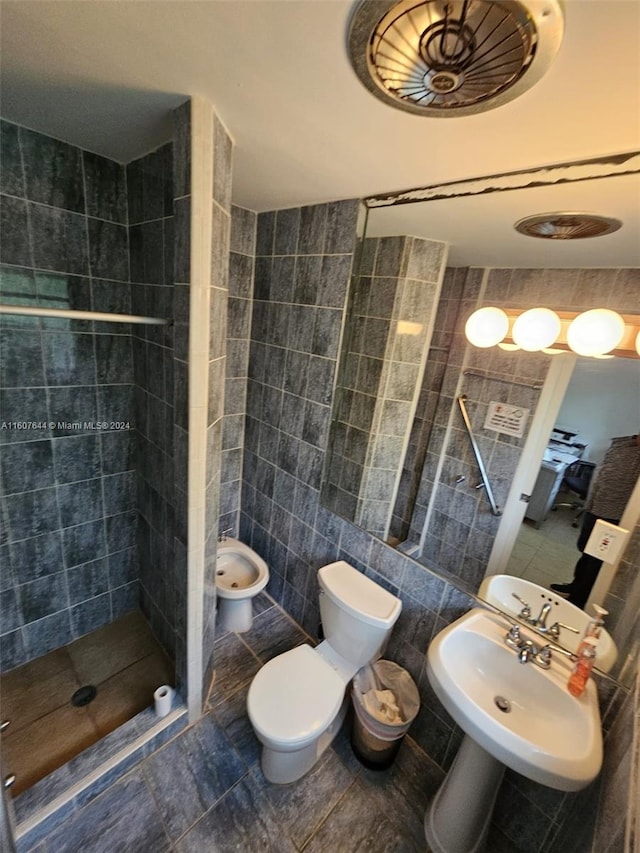 bathroom with a bidet, tile walls, toilet, and tile patterned flooring