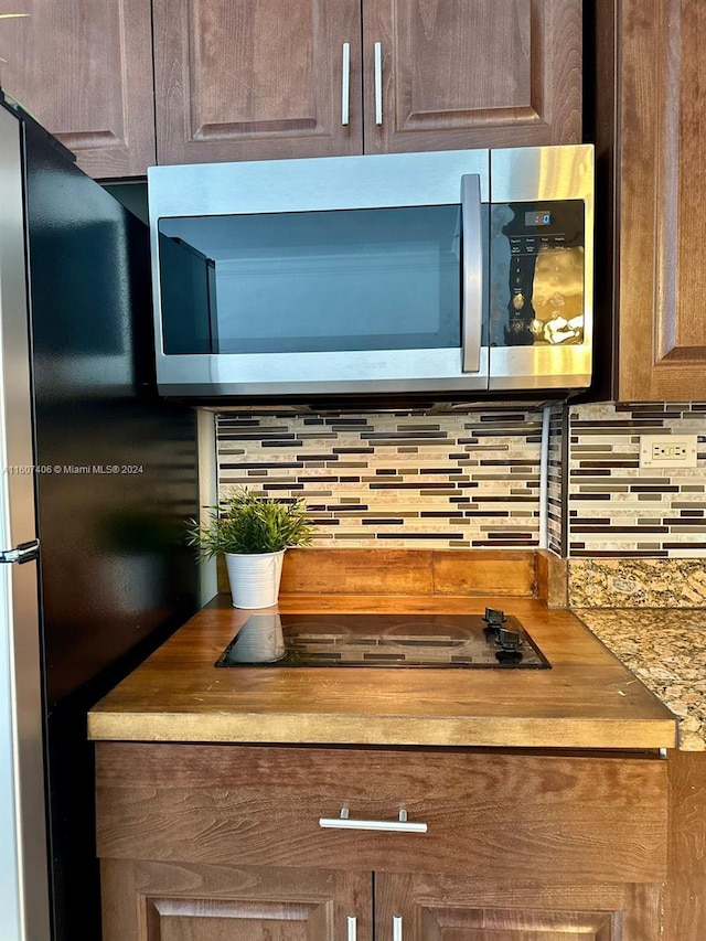 room details featuring stainless steel appliances and decorative backsplash