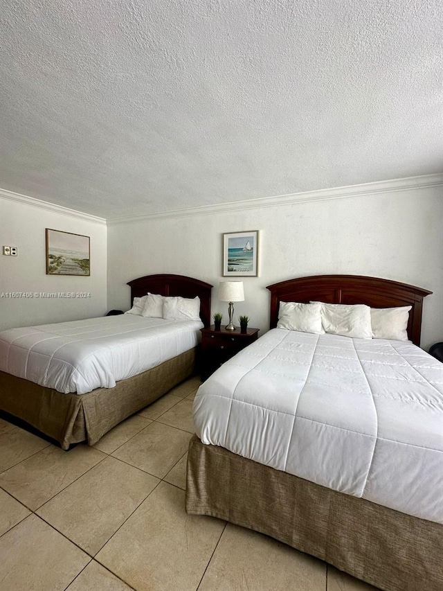 bedroom with ornamental molding, a textured ceiling, and tile patterned floors