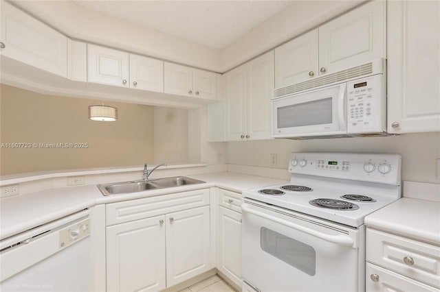 kitchen with white cabinetry, sink, light tile patterned floors, and white appliances