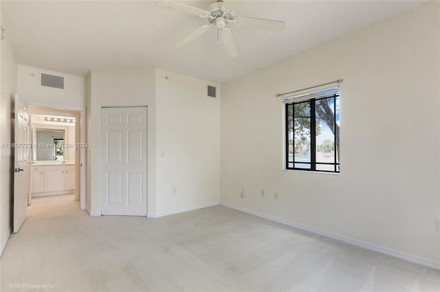 unfurnished bedroom featuring light carpet, a closet, and ceiling fan