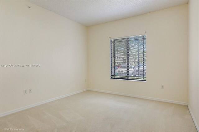 carpeted empty room with a textured ceiling