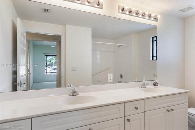 bathroom with a shower, vanity, and toilet