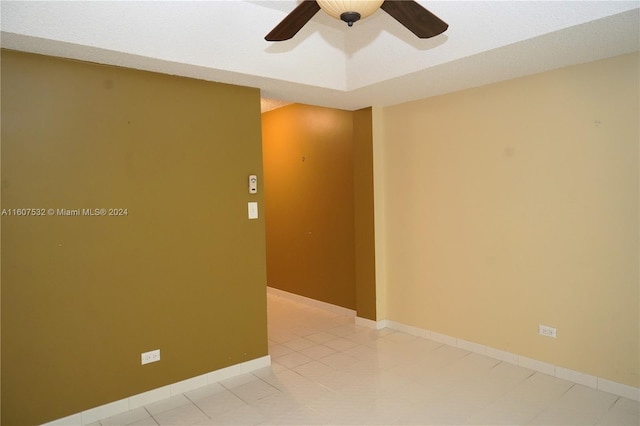 spare room with ceiling fan and light tile flooring