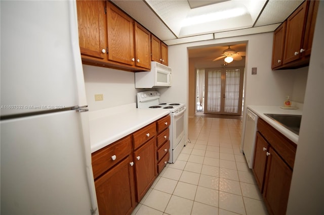 kitchen with ceiling fan, sink, white appliances, and light tile floors