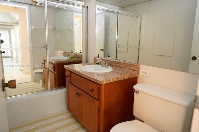 full bathroom featuring tile floors, bath / shower combo with glass door, vanity, and toilet