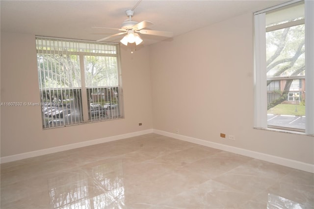 spare room with plenty of natural light, ceiling fan, and tile floors