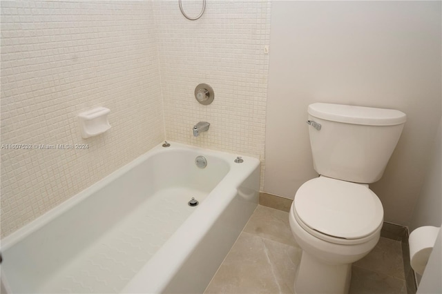 bathroom featuring tile flooring, toilet, and tiled shower / bath