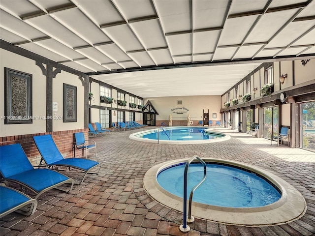 view of pool with a patio and an indoor hot tub