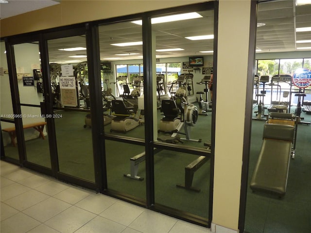 exercise room with a paneled ceiling and plenty of natural light