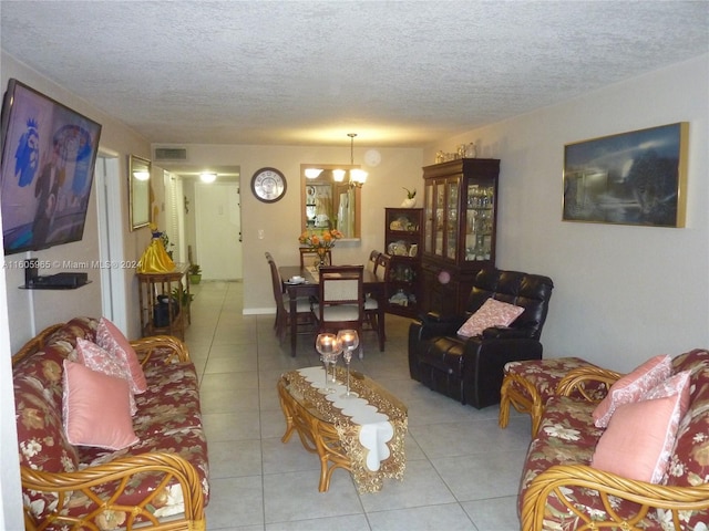 living room with light tile patterned floors, a textured ceiling, and a notable chandelier