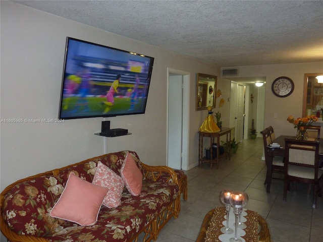 tiled living room featuring a textured ceiling