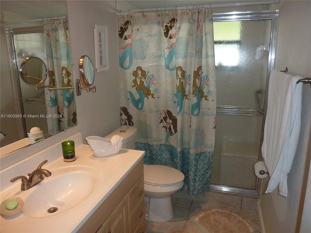 bathroom featuring tile patterned floors, toilet, vanity, and walk in shower