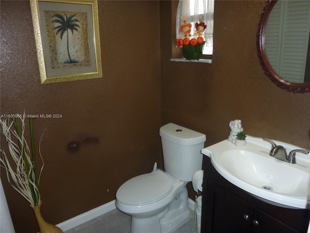 bathroom featuring tile patterned flooring, vanity, and toilet