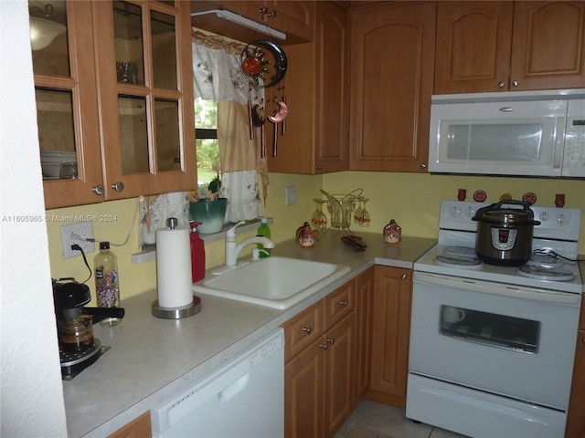 kitchen featuring white appliances, sink, and light tile patterned floors