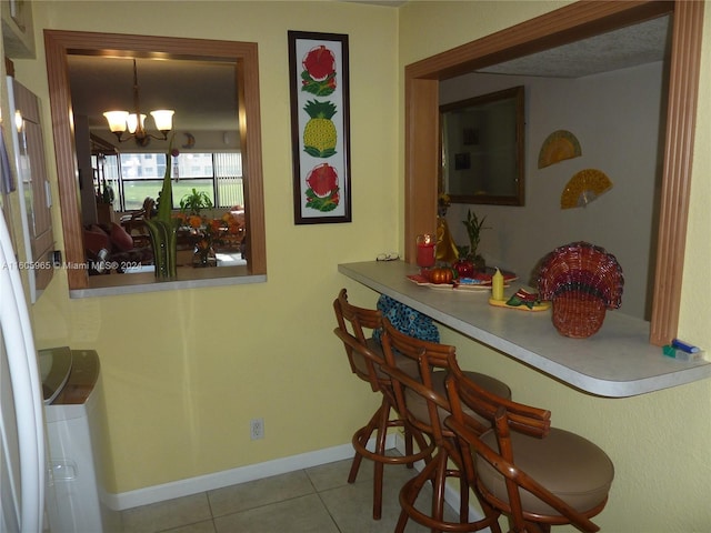 tiled dining area featuring a notable chandelier