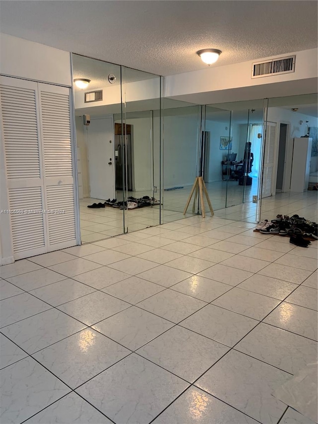 interior space with tile flooring and a textured ceiling