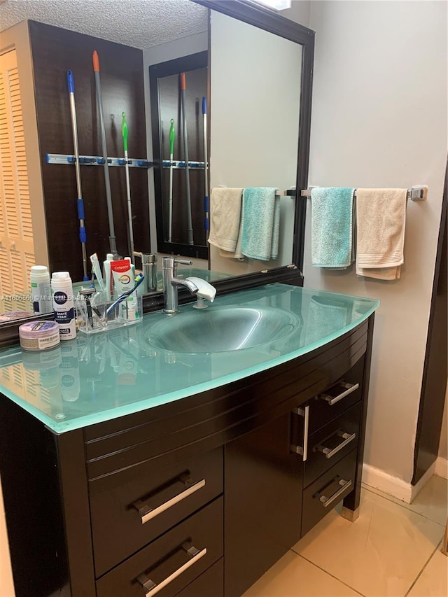 bathroom with tile floors, a textured ceiling, and vanity