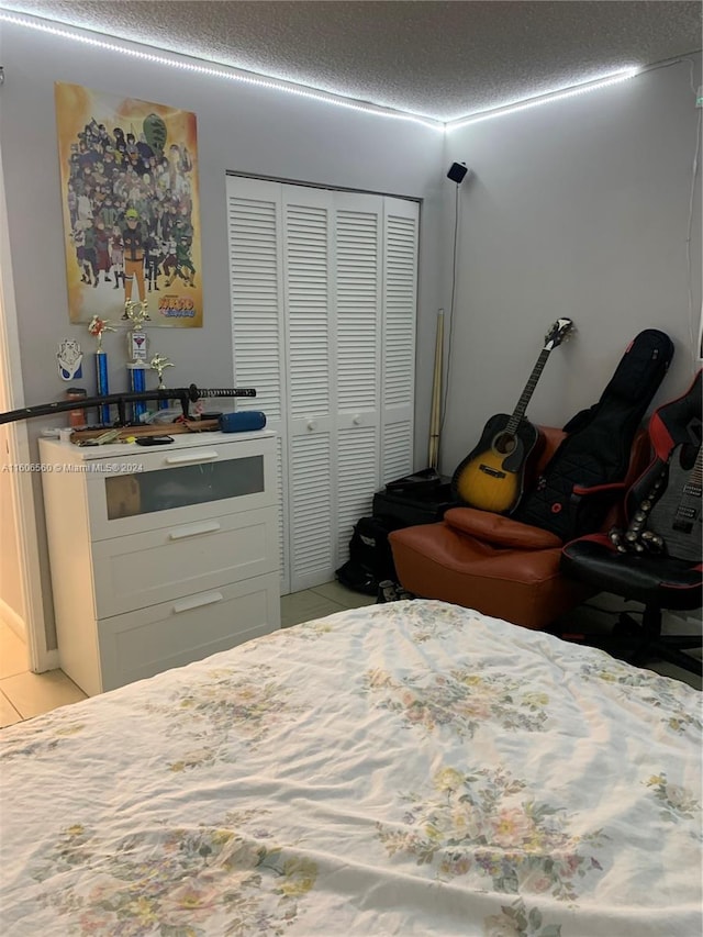 tiled bedroom featuring a textured ceiling and a closet