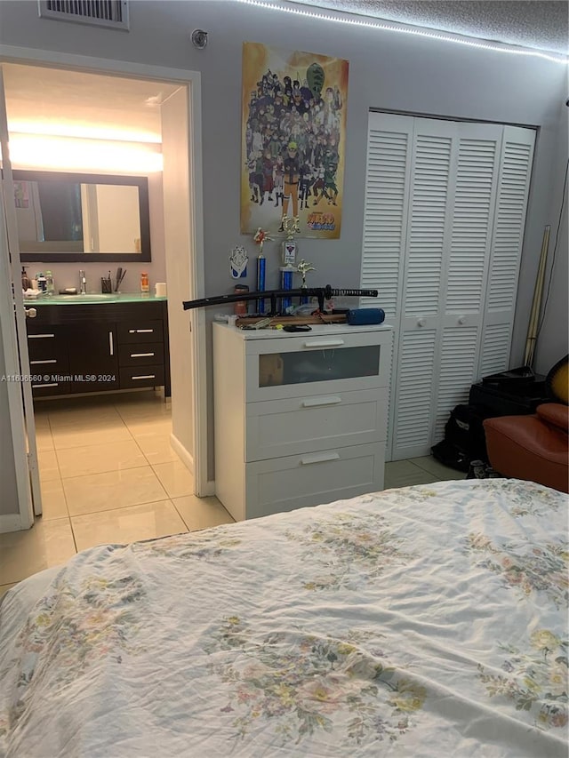 tiled bedroom featuring sink and a closet