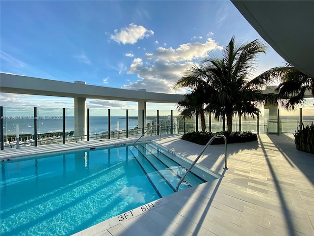 view of swimming pool with a water view