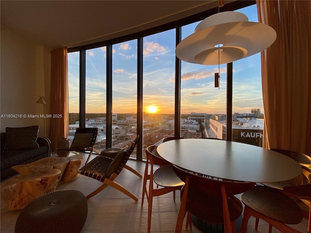 dining space with a wealth of natural light, floor to ceiling windows, and a city view