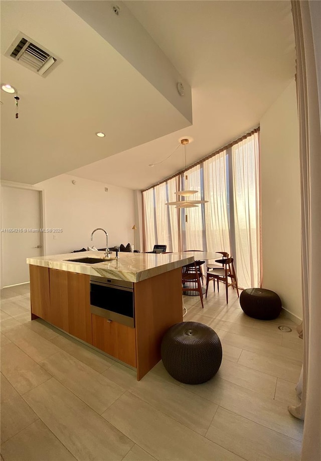 kitchen with visible vents, modern cabinets, light countertops, a sink, and a warming drawer