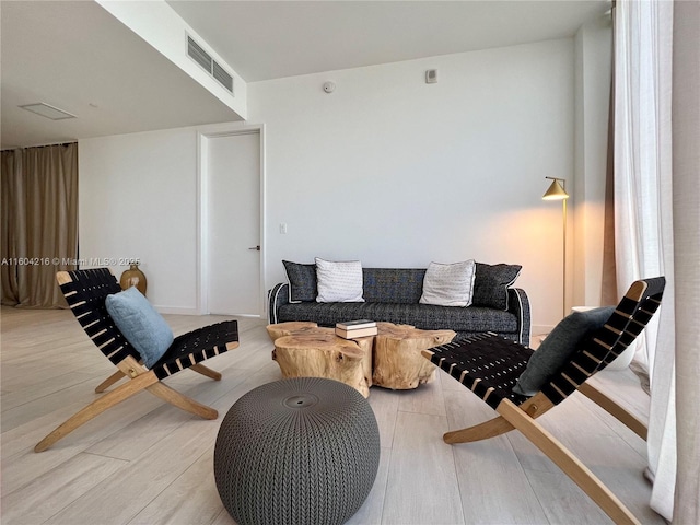 living room with light wood-type flooring and visible vents