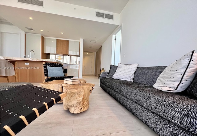 living room featuring light wood finished floors, visible vents, and recessed lighting