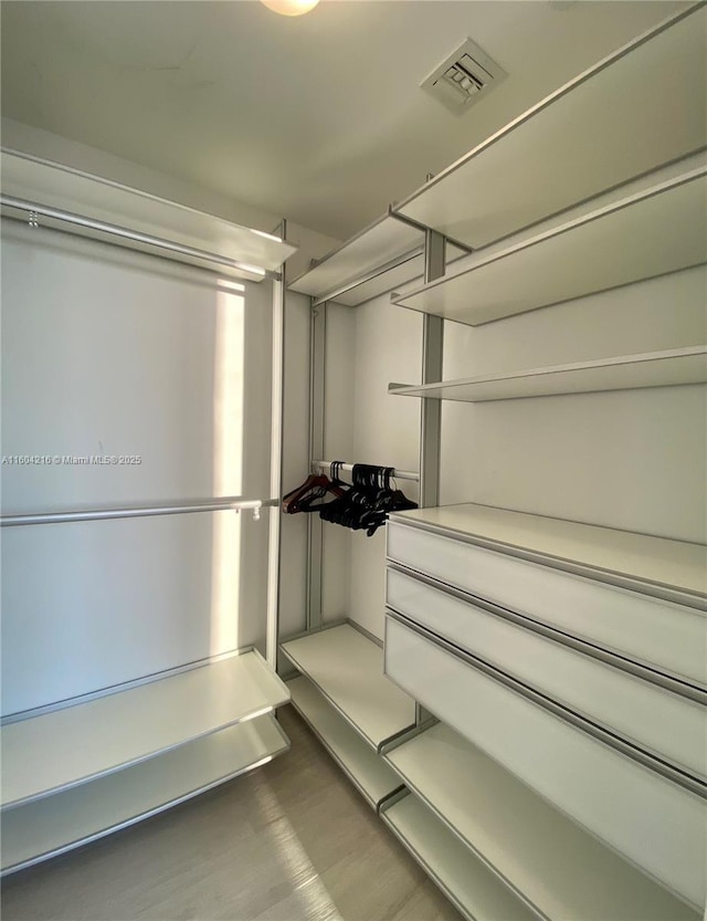 walk in closet featuring visible vents and wood finished floors