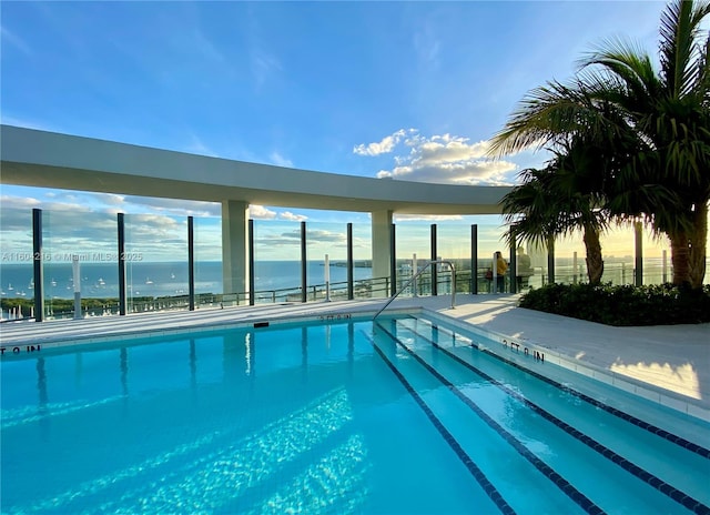 view of swimming pool with a water view