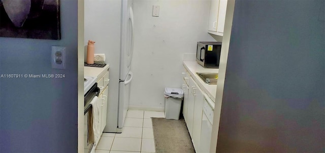 kitchen with sink, white cabinets, stainless steel appliances, and light tile patterned floors