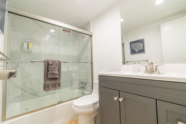 full bathroom with shower / bath combination with glass door, vanity, and toilet