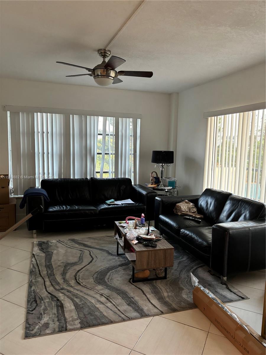 living room with ceiling fan and tile patterned flooring