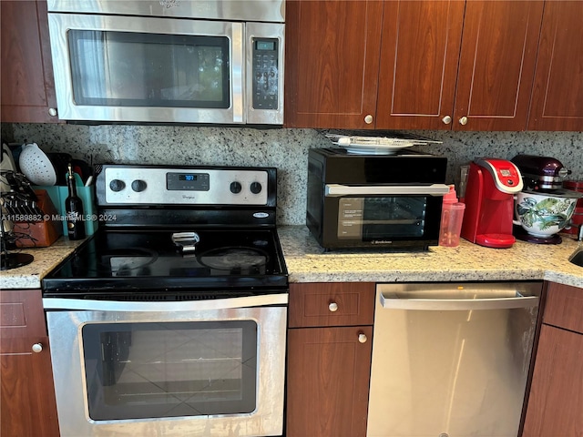 kitchen featuring stainless steel appliances and light stone countertops