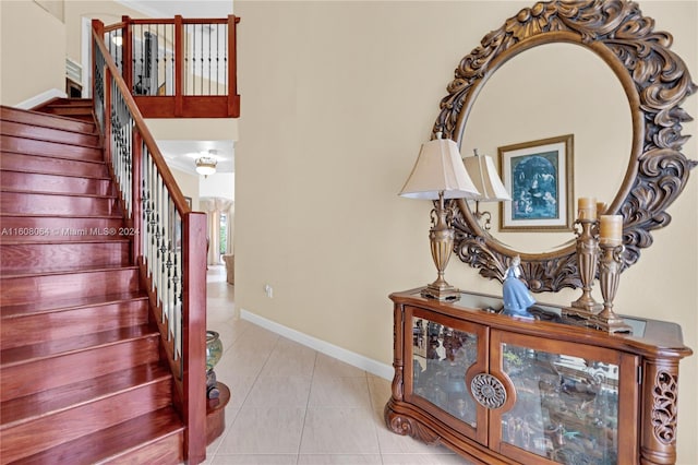 stairway featuring baseboards and tile patterned floors