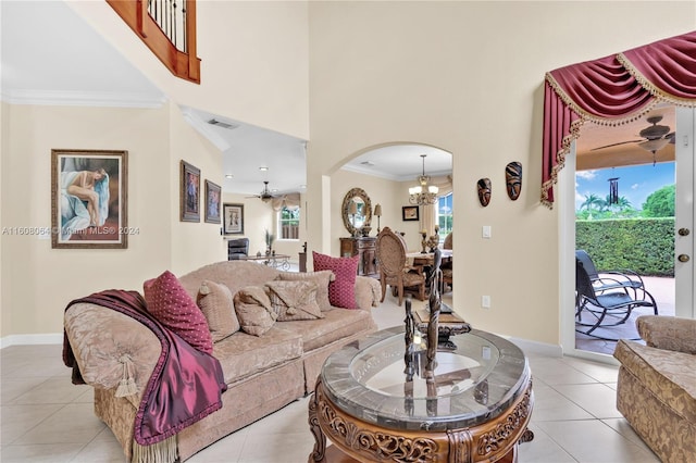 living room featuring arched walkways, light tile patterned floors, visible vents, ornamental molding, and ceiling fan with notable chandelier