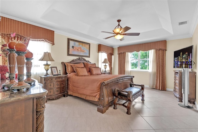 bedroom with light tile patterned floors, visible vents, a raised ceiling, a ceiling fan, and crown molding