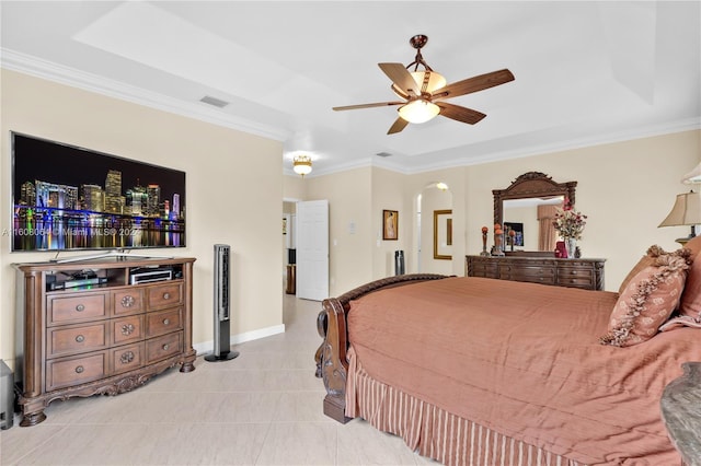 bedroom with visible vents, arched walkways, a tray ceiling, and ornamental molding