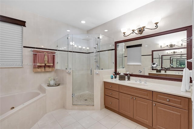 bathroom with a stall shower, a tub with jets, tile patterned flooring, vanity, and tile walls