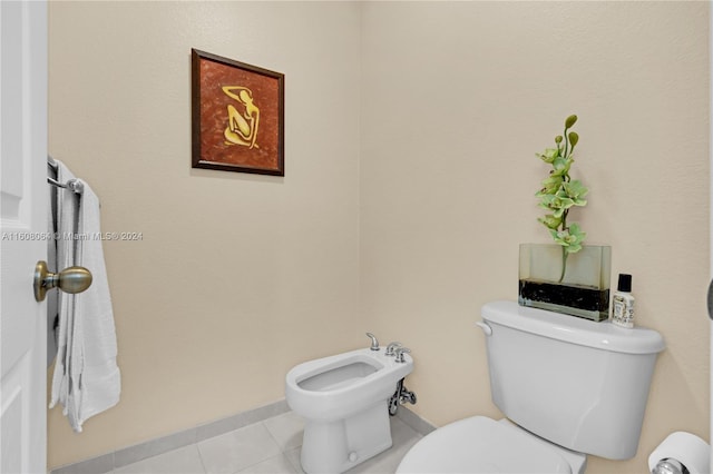 half bath featuring toilet, tile patterned flooring, a bidet, and baseboards