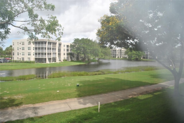 view of community with a lawn and a water view